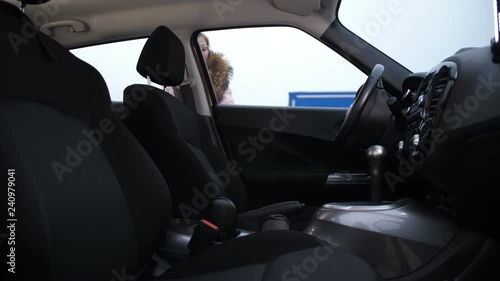 The blonde girl gets in the car, throws a handbag on the passenger seat. She is very cold, she is heated in the car 4K Slow Mo