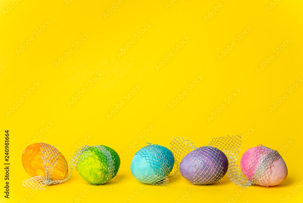 Fototapeta premium colorful, hand-painted, pastel Easter eggs on a bright, yellow, spring background