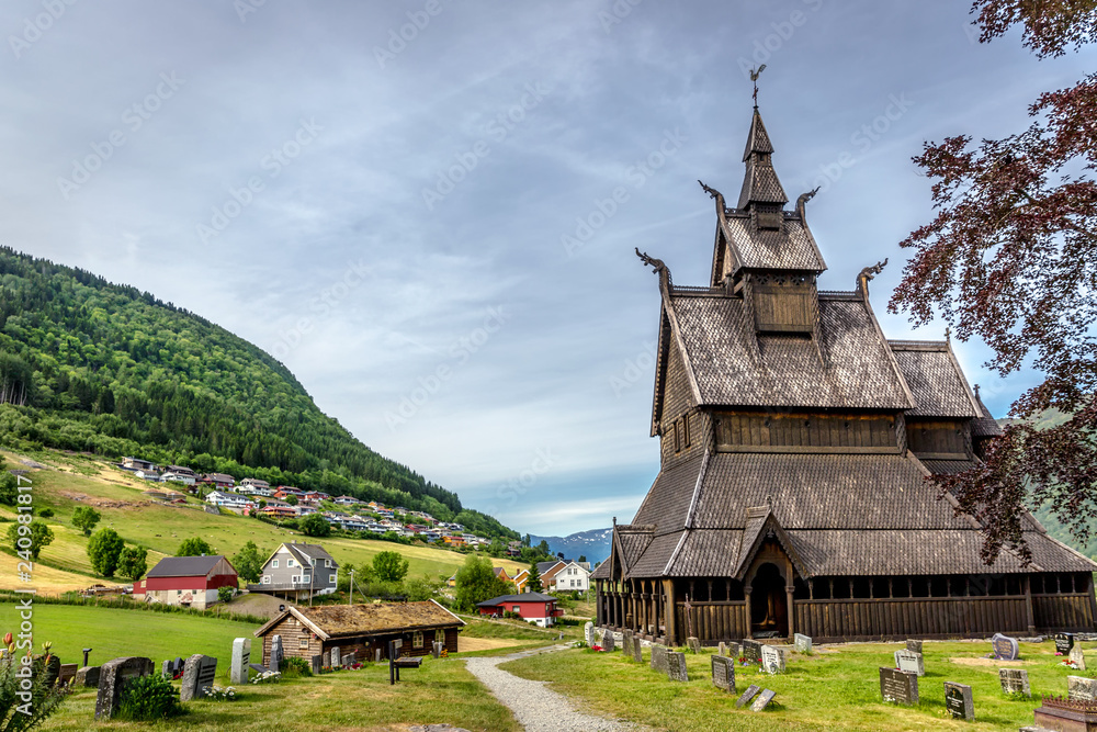 A wood church in a green grass field in Norway