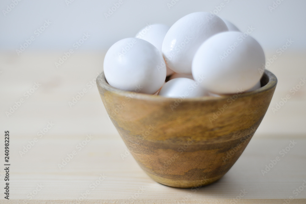 white eggs on wooden plate on wooden background , copy space white eggs on wooden plate on wooden background , copy space