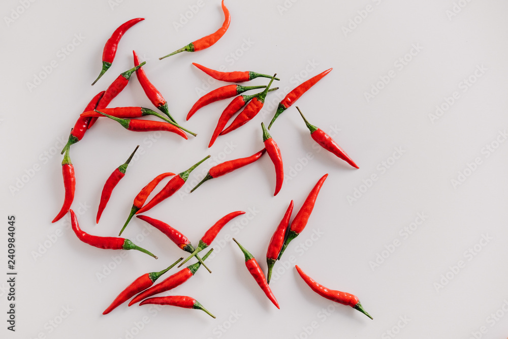 a lot of small red chili peppers on white background a lot of small red chili peppers on white background