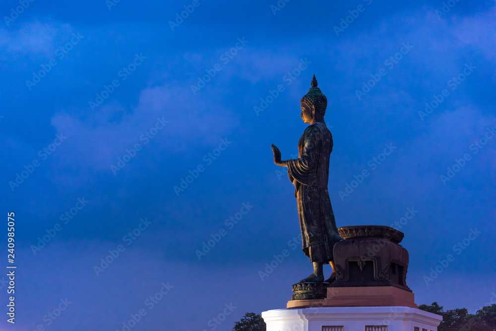 Obraz premium large bronze statue of Buddha standing on an outdoor platform