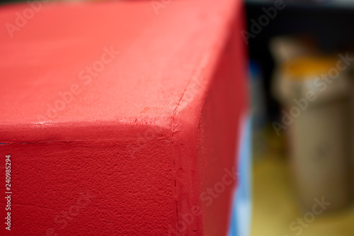 Male hand painting wall with paint roller. Painting apartment, renovating with red color paint