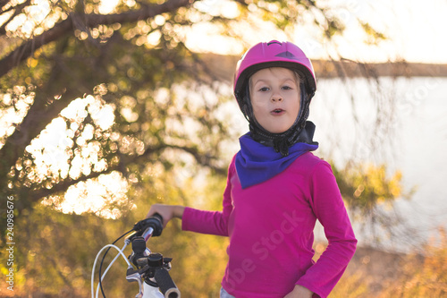 Portrait of a little girl in a helmet with a bicycle