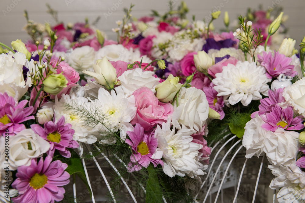 Various bridal flower heads in vintage ornate bird cage as bloom decoration at a wedding reception