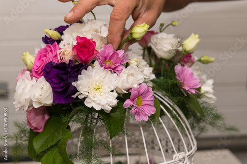 Various bridal flower heads in vintage ornate bird cage as bloom decoration at a wedding reception