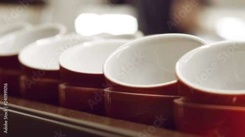 Empty red cups for espresso and for coffee and milk standing and warming up on the surface of the coffee machine