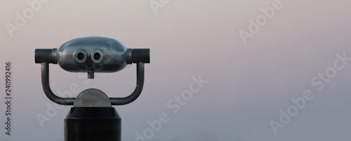 Coin Operated Binocular viewer next to the waterside promenade in Sea looking out to the Bay. Landscape with beautiful sunset and sea.Place for your text.