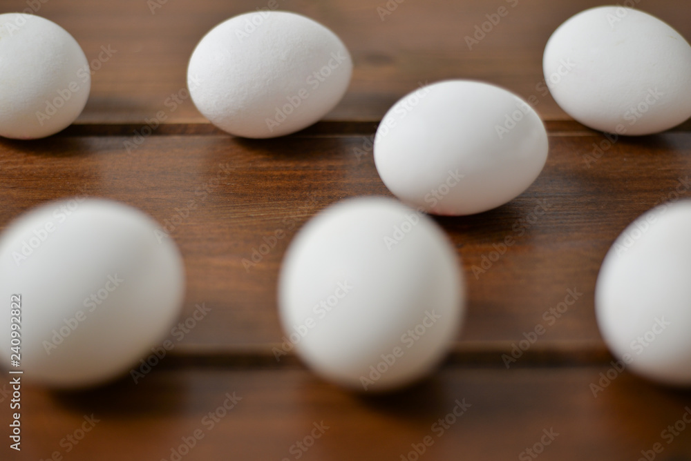 white eggs on wooden plate on wooden background , copy space 