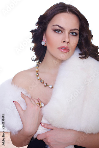Portrait of a young beautiful brunette girl in a white fur collarover
