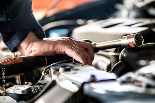 Engine repair technicians are hold the wrench in order to repair the car..