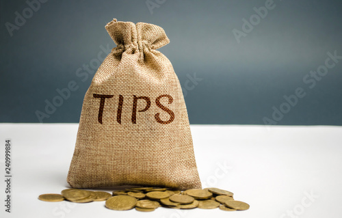 Money bag with the word Tips. Award for good service in the cafe / restaurant. A gratuity is a sum of money customarily given by a client or customer to a service worker in addition to the basic price