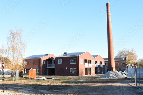 nieuwe woningen op een oud fabrieksterrein met oude schoorsteenpijp photo