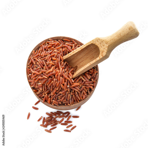 Bowl and scoop with uncooked red rice on white background, top view