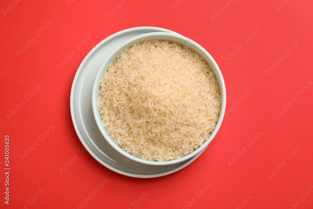 Bowl with uncooked rice on color background, top view Bowl with uncooked rice on color background, top view