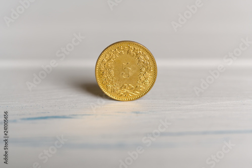 A 5 cents Swiss coin standing on a wooden background