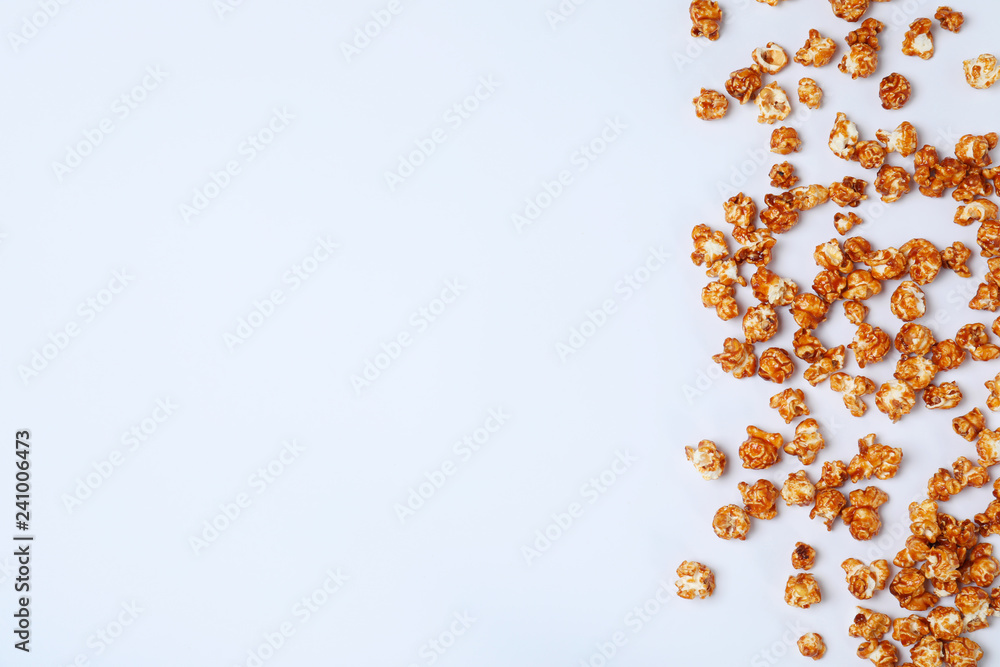 Flat lay composition with caramel popcorn and space for text on white background