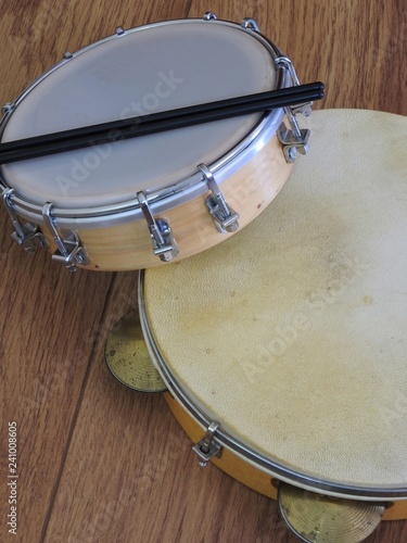 Close-up of two Brazilian musical percussion instruments: pandeiro (tambourine) and tamborim with drumstick. They are widely used to accompany samba, the most popular Brazilian rhythm. photo