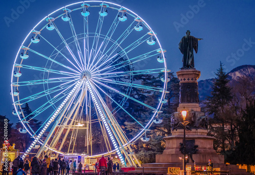 The big panoramic wheel in Dante Alighieri square in Trento city at night during the Christmas festivity. Christmas market in Trento, Trentino Alto Adige, Italy