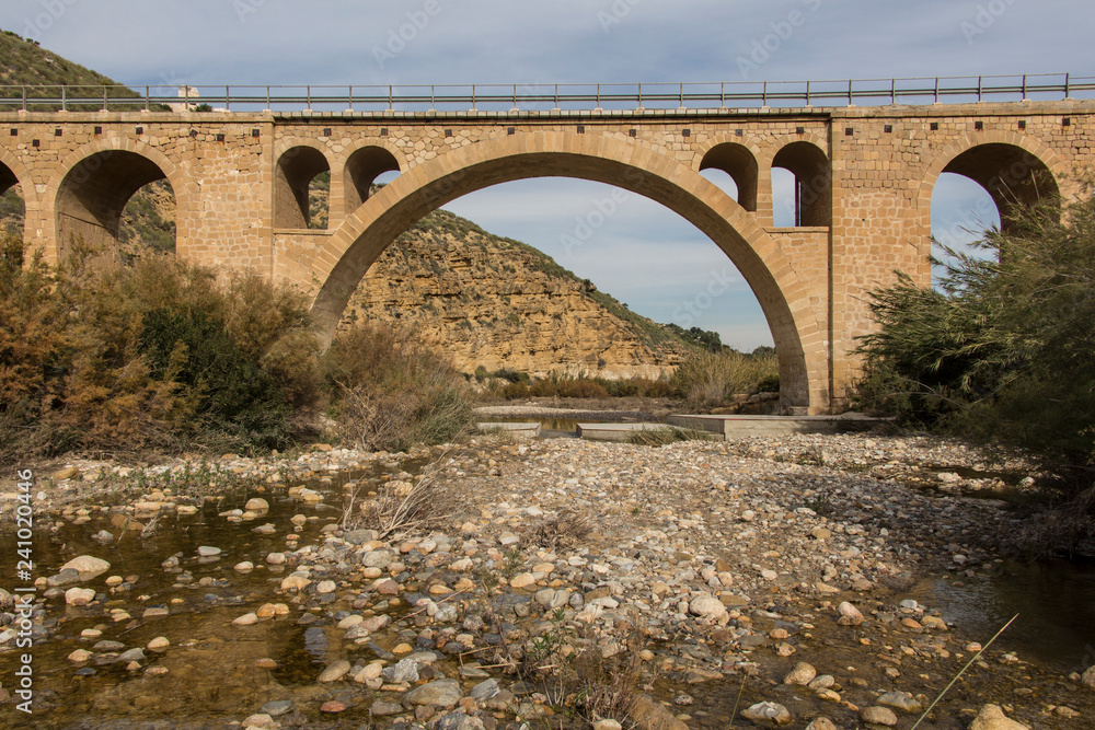 old stone bridge across the river, province of almeria, region of andalucia, spain