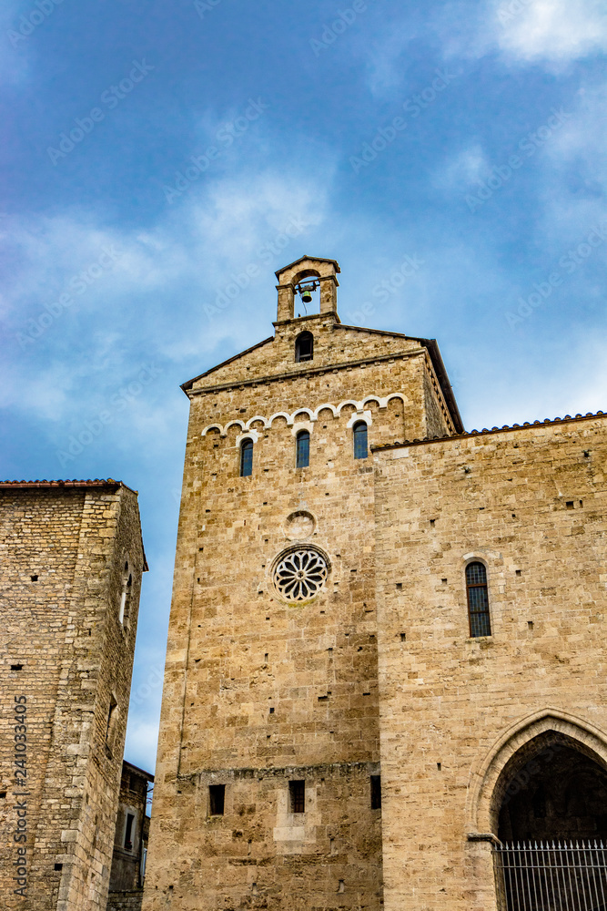 Side facade of the Cathedral Basilica of Santa Maria Annunziata, with the rose window, in Piazza Innocenzo III. Stone buildings from the Middle Ages. Anagni, Frosinone, Italy.
