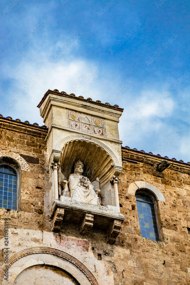 Obraz premium Cathedral Basilica of Santa Maria Annunziata, in Piazza Innocenzo III. Niche with the statue of Pope Boniface VIII, seated and blessing, on the cathedral terrace. Anagni, Frosinone, Italy.