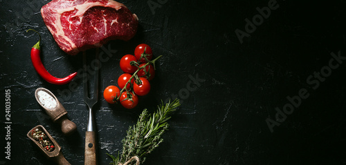 a piece of fresh beef. rib-eye steak. with accompanying ingredients for cooking. concept of delicious dinner.