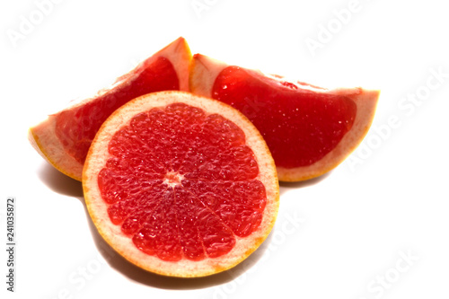 Pink ripe grapefruit slice on white isolated background. Half and slice of grapefruit isolated on white.