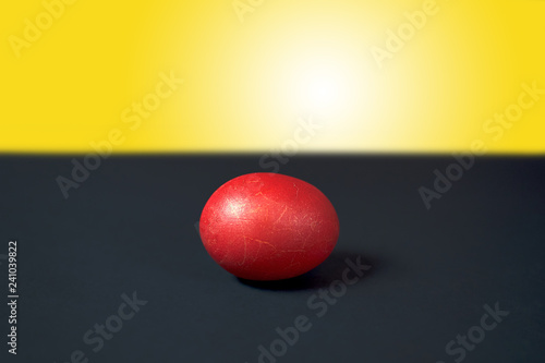 Red Easter egg on black and yellow background. Decoration for easter.