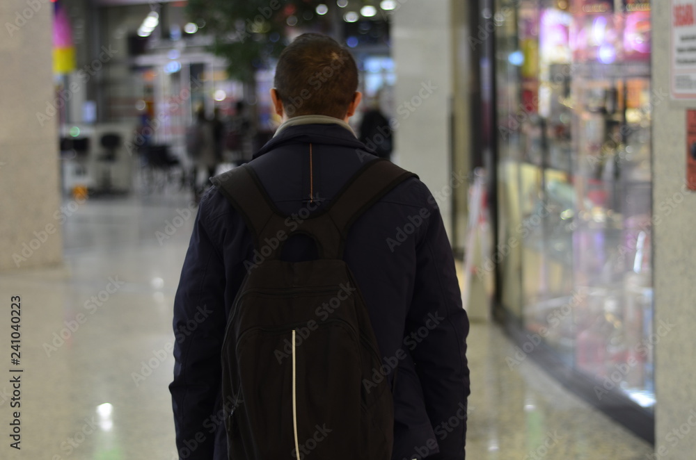 man with black backpack stands man with black backpack stands