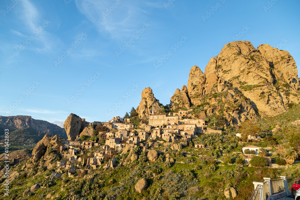 Piccolo paese abbandonato in montagna con case e chiese sul pendio vicino le rocce in Calabria. Pentedattilo.