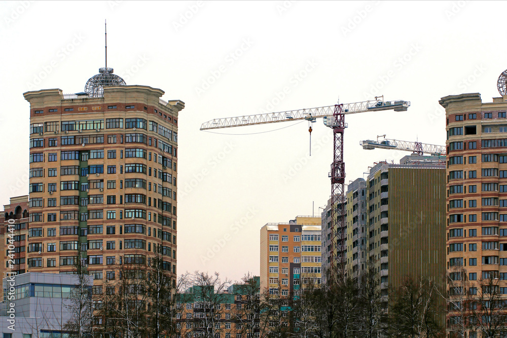 Under construction apartment building and tower crane on a construction site Under construction apartment building and tower crane on a construction site