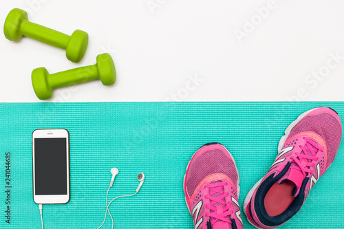 healthy lifestyle. Sport and healthy nutrition. Top view of sports equipment, dumbbells and running shoes, yoga mat and telephone. Flat lay with space for text