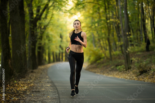 Runner caucasian woman jogging in green park. Healthlife concept.