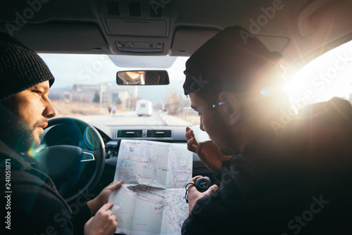 Fotografie Bank robbers,planning their next hit while holding a gun and counting on a stop watch the time they need to get from one point on the map to another one