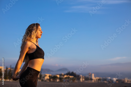 Young woman does sport on the beach