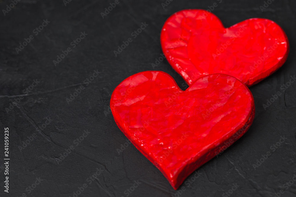 Valentine's Day. Two red heart shape with copy space on black texture background