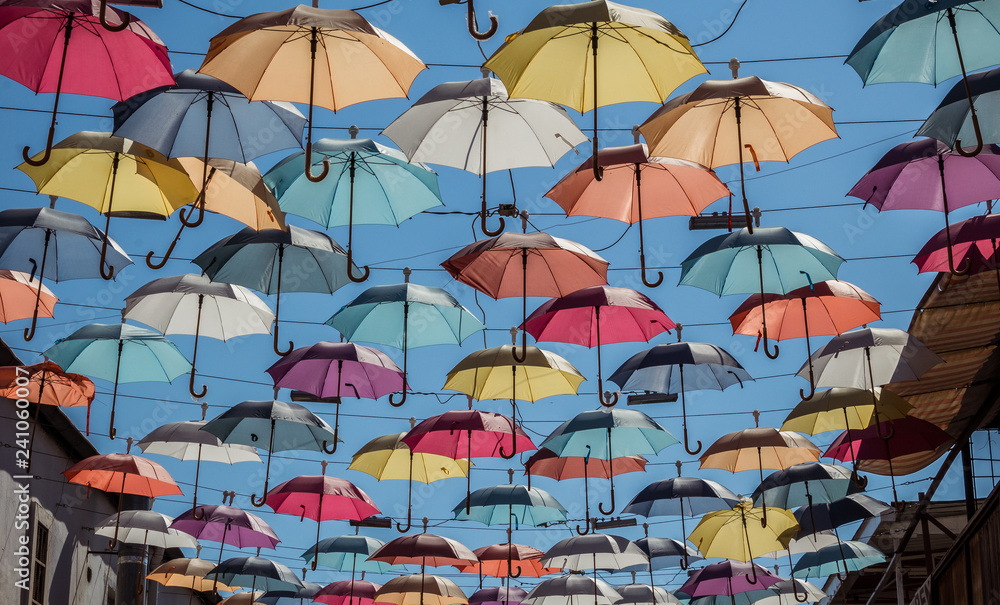 Low angle of colorful umbrellas hanging in rows and decorating street on sunny day in summer in Antalya