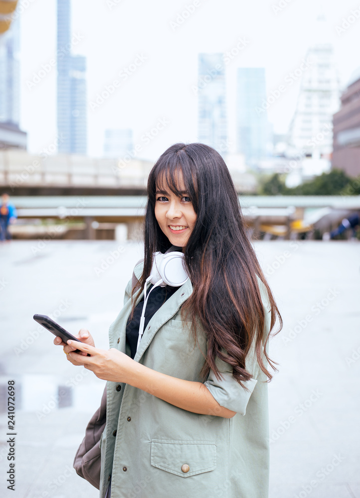 Fototapeta premium Portrait beautiful asian woman using mobilephone and walking in the city,Female confidence happy and smiling,Lifestyle concept