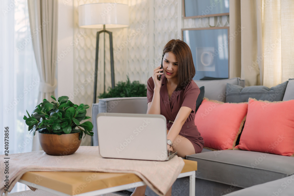 Beautiful Asian businesswoman discuss mobile phone calls with customers and work on laptops at home or modern offices. Beautiful Asian businesswoman discuss mobile phone calls with customers and work on laptops at home or modern offices.