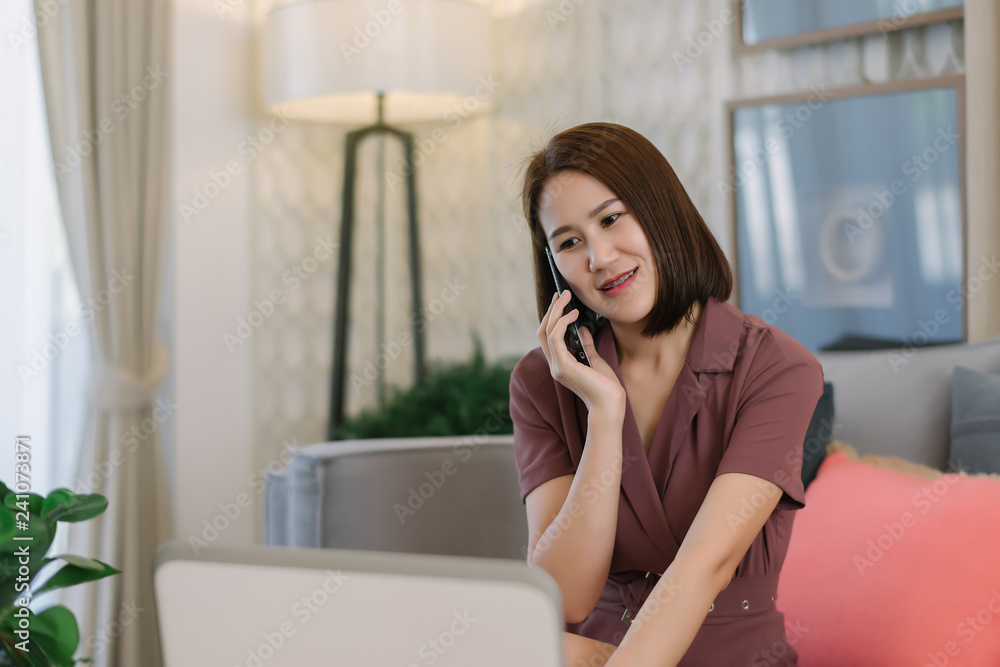 Beautiful Asian businesswoman discuss mobile phone calls with customers and work on laptops at home or modern offices. Beautiful Asian businesswoman discuss mobile phone calls with customers and work on laptops at home or modern offices.