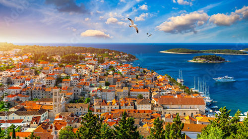 Hvar town with seagull's flying over city, famous luxury travel destination in Croatia. Boats on Hvar island, one of the many Islands near Dubrovnik and Korcula on the Dalmatian Coast of Croatia.