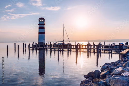 Lighthouse at Lake Neusiedl  Podersdorf am See  Burgenland  Austria. Lighthouse at sunset in Austria. Wooden pier with lighthouse in Podersdorf on lake Neusiedl in Austria.