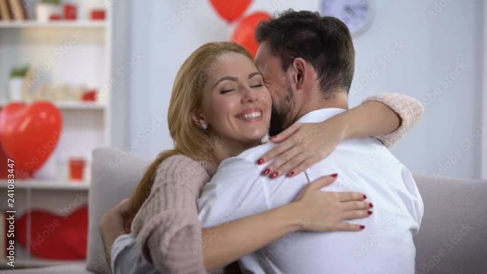 Passionate husband and wife nuzzling and hugging, spending holiday together Passionate husband and wife nuzzling and hugging, spending holiday together