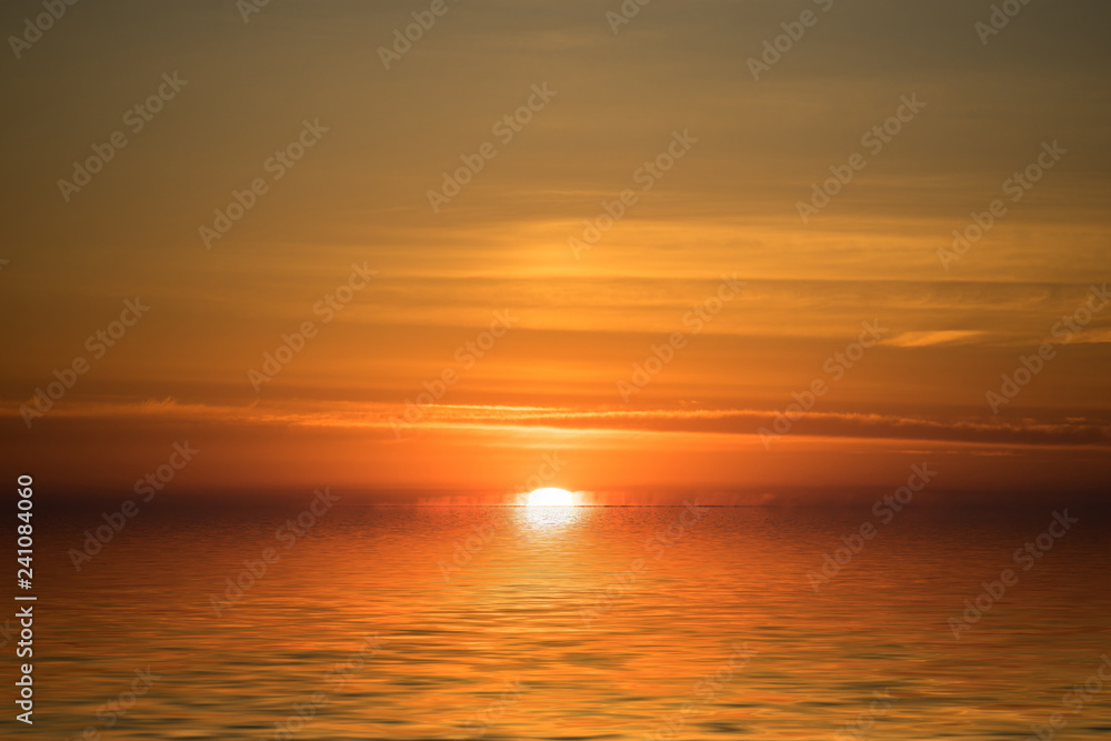 Bright dramatic sunset on the background of the calm sea.