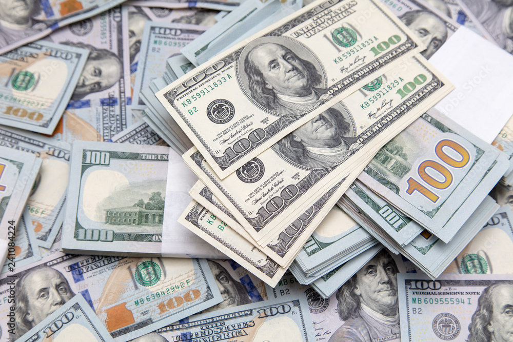 One hundred dollar bills on the table as background One hundred dollar bills on the table as background