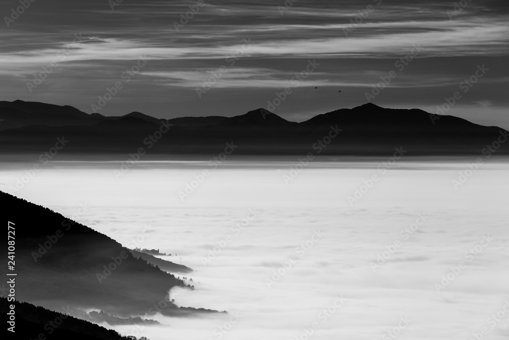 Fog filling a valley in Umbria (Italy), with layers of mountains and hills Fog filling a valley in Umbria (Italy), with layers of mountains and hills