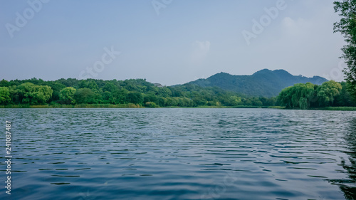 Calm water and surrounding hills of West Lake, in the Maojiabu area, in Hangzhou, China photo