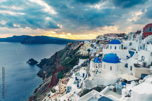 Churches in Oia, Santorini island in Greece, at sunset. Travel background.