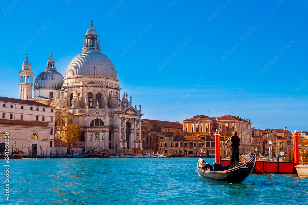 Gondolier striped jacket is on oars blue river in Venice, example of ancient architecture with several grey domes
